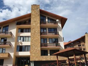 a tall apartment building with balconies and an umbrella at Bakuriani K-2 Apartment in Bakuriani