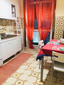 a kitchen with a table and a red curtain at Natura Bella appartamento in Montoro Inferiore