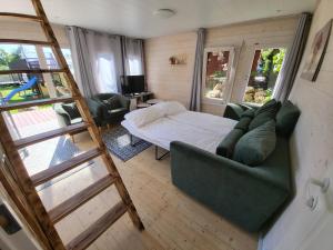 ein Wohnzimmer mit einem Sofa, einem Bett und einer Leiter in der Unterkunft Tiny house near Viljandi lake in Viljandi