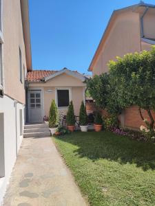 a small house with a yard with a sidewalk at Flora Apartment in Surčin