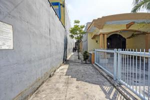 een steegje met een wit hek naast een gebouw bij OYO 3285 Wonoayu Residence Syariah in Sidoarjo