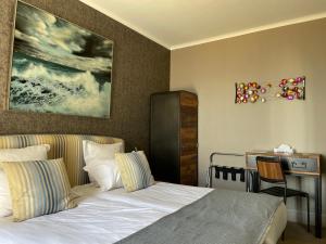 - une chambre avec un lit, un bureau et une table dans l'établissement Hôtel de la Pointe du Grouin, à Cancale