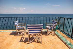 3 sillas sentadas en un balcón con vistas al océano en Villa Levante - Direct Sea Access - Full Sea View - Amalfi Coast en Cetara