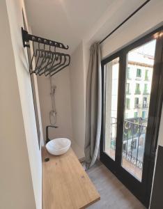 Habitación con baño con lavabo y ventana. en Casa de huéspedes Mi lla, en Madrid