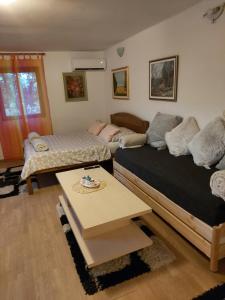 Studio apartman KOTRO في Beli Manastir: غرفة نوم بسريرين وطاولة قهوة