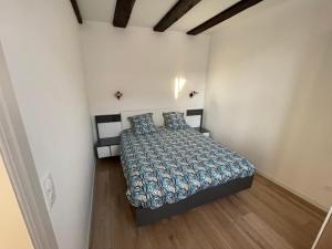 sypialnia z łóżkiem w białym pokoju w obiekcie appartement le fil d'or w mieście Colmar