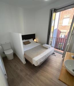1 dormitorio con 1 cama y baño con lavamanos en Casa de huéspedes Mi lla, en Madrid