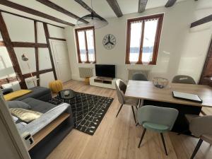 a living room with a table and a dining room at appartement le fil d'or in Colmar