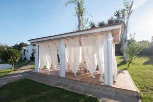 um pavilhão com cortinas brancas num quintal em Agradable Villa con piscina em Sevilha
