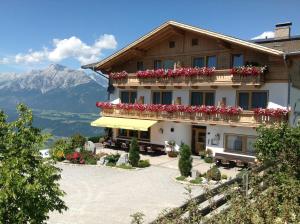 un edificio con fiori sui balconi con montagne sullo sfondo di Ferienpension Steiner a Weerberg