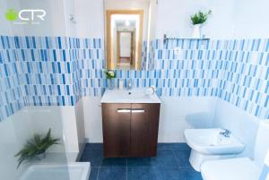 ein blau-weißes Bad mit einem Waschbecken und einem WC in der Unterkunft LARGE COMPLETE APARTMENT, In The Center With Balcony in Santiago de Compostela