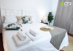 ein weißes Bett mit Handtüchern darüber in der Unterkunft LARGE COMPLETE APARTMENT, In The Center With Balcony in Santiago de Compostela