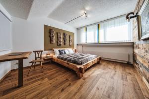 a bedroom with a bed and a desk and a window at Casa Tschierva in Davos