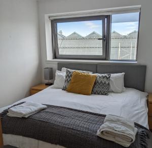 a bedroom with a bed with a large window at Glasgow City Centre Waterfront Apartment in Glasgow