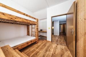 Pokój z 2 łóżkami piętrowymi i drzwiami w obiekcie Casa Tschierva w Davos