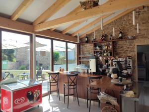 a kitchen with a bar with chairs and tables at A Casa Do Boi in Amés