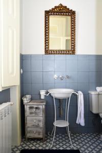 uma casa de banho azul com um lavatório e um espelho em Casa Galricho em Murtosa