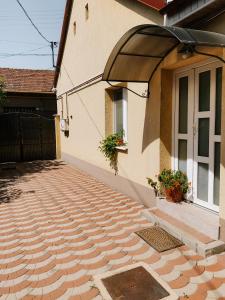 une maison avec un trottoir en briques à côté d'une porte dans l'établissement Cozy 2-Bedroom Boho-Themed Home, à Caransebeş