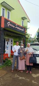 a group of three people standing in front of a store at Green Savanah Homestay Syariah in Diyeng