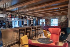 un bar con sedie colorate e bancone di CASPAR Swiss Quality Hotel a Muri