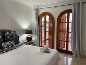 una cama con un osito de peluche sentado en un dormitorio en Villa Cana, en San Roque