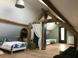 Zimmer im Dachgeschoss mit einem Bett und einem Sofa in der Unterkunft Gîte de la Kélidoine in Montigny-sur-Armançon