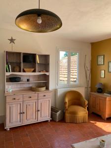 ein Wohnzimmer mit einem Stuhl und einem Kronleuchter in der Unterkunft Gîte de la Kélidoine in Montigny-sur-Armançon