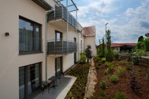 um edifício de apartamentos com uma varanda e um jardim em Hotel Zum Grünen Baum em Pfahlheim