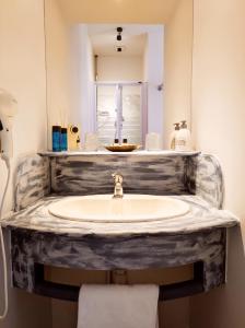 La salle de bains est pourvue d'un lavabo et d'un miroir. dans l'établissement La Verrerie, à Gaillac
