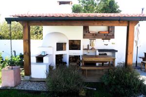 a patio with a pizza oven and a table at Casa Galricho in Murtosa