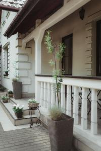 a porch of a house with potted plants on it at Dworek Złoty Róg Hotel i Restauracja in Krakow