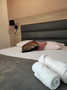 Una cama con dos toallas blancas. en La Verrerie en Gaillac