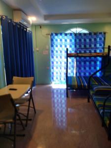 a room with blue curtains and a table and chairs at Azulea Lodging House Oslob in Oslob