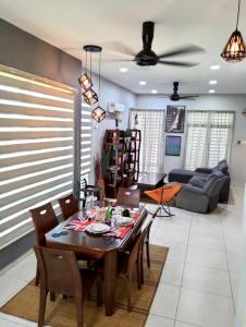 a dining room and living room with a table and chairs at JOE Homestay in Alor Setar