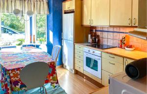 a kitchen with a table and a kitchen with blue walls at 2 Bedroom Nice Home In Timmersdala in Götene