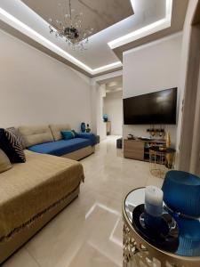 uma sala de estar com um sofá e uma televisão em Rika’s seaside apartments em Chania Town