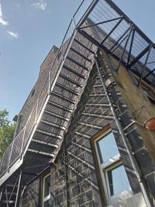 a fire escape on the side of a building with stairs at Treetops & Viaducts; open plan two-bed apartment in Walsden