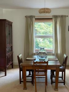 a dining room table with chairs and a vase on it at Treetops & Viaducts; open plan two-bed apartment in Walsden