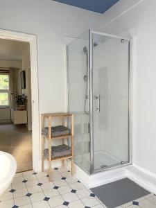 a bathroom with a shower with a glass door at Treetops & Viaducts; open plan two-bed apartment in Walsden