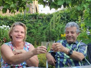 een oudere man en vrouw met een glas wijn bij B & B Ayo in Wapserveen