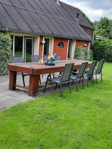 een houten tafel met stoelen en een pop bovenop bij B & B Ayo in Wapserveen