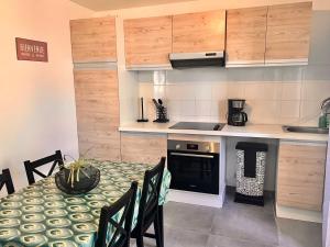a small kitchen with a table and a stove at Villa 2 chambres proche d’un Lac in Ruelle-sur-Touvre