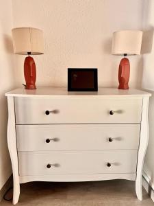 a white dresser with two lamps on top of it at Villa 2 chambres proche d’un Lac in Ruelle-sur-Touvre