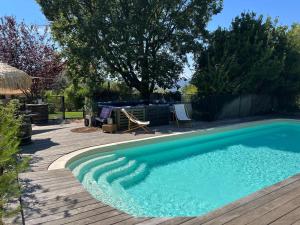 Auriol的住宿－La Maison Perchée，一个带木甲板的庭院内的游泳池