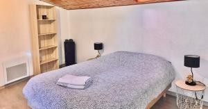 1 dormitorio con 1 cama y 2 lámparas y estanterías en Villa 2 chambres proche d’un Lac en Ruelle-sur-Touvre