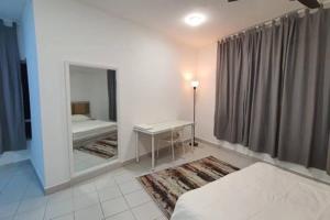1 dormitorio con espejo, cama y escritorio en Double AS Homestay, en Putrajaya