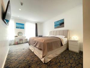 ein weißes Schlafzimmer mit einem großen Bett und einem Fenster in der Unterkunft ART HOTEL HOUSE ONE in Baden-Baden