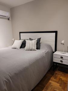 um quarto com uma cama grande e uma mesa de cabeceira em BE Apartments Vicente em Mendoza