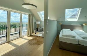 a bedroom with a bed and a room with a balcony at Westeroog in Wangerooge