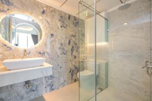 a bathroom with a sink and a glass shower at Căn Hộ View Biển Santorini, Vũng Tàu in Vung Tau +45 photos